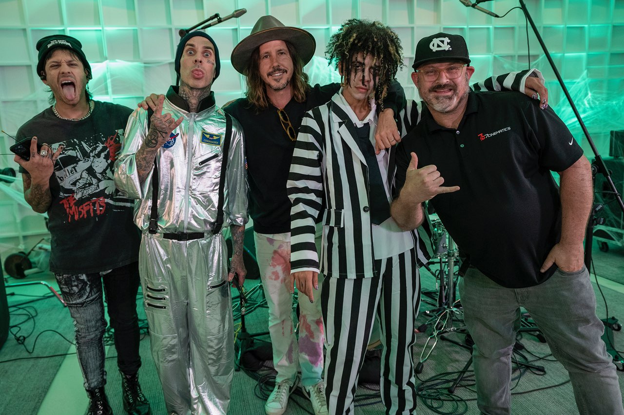 Musicians and crew gathered in a green-lit studio